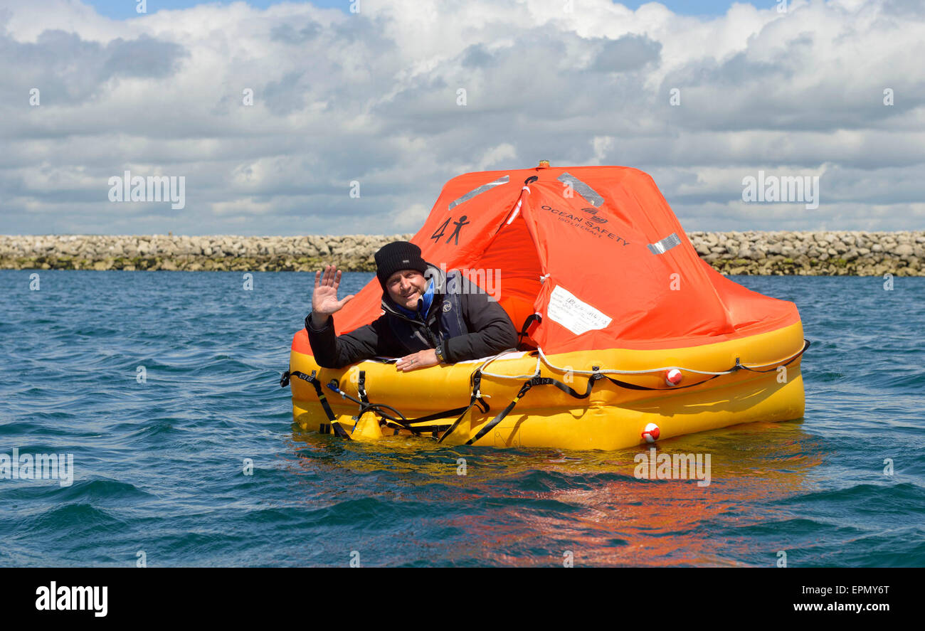 Portland Harbour, Dorset, UK. 18th May, 2015. A former soldier is hoping his seven days and nights in a life raft will be a lifeline to Great Ormond Street Hospital too in his unique fundraising effort.  His tiny life raft was towed out to a bouy and secured there in Portland Harbour today (mon) until next Monday as he started his survival period with just the items that one would have on such an emergency craft. Wayne Ingram, from Portland, has raised thousands of pounds for children around the world but now wants to do his bit for children in the UK. Credit:  Dorset Media Service/Alamy Live  Stock Photo