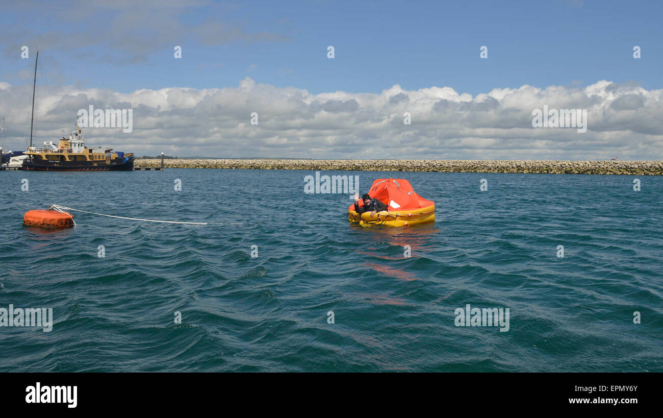 Portland Harbour, Dorset, UK. 18th May, 2015. A former soldier is hoping his seven days and nights in a life raft will be a lifeline to Great Ormond Street Hospital too in his unique fundraising effort.  His tiny life raft was towed out to a bouy and secured there in Portland Harbour today (mon) until next Monday as he started his survival period with just the items that one would have on such an emergency craft. Wayne Ingram, from Portland, has raised thousands of pounds for children around the world but now wants to do his bit for children in the UK. Credit:  Dorset Media Service/Alamy Live  Stock Photo