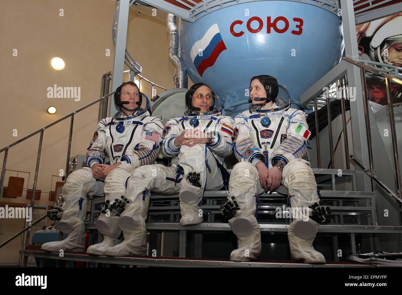 International Space Station Expedition 40 backup crew members NASA astronaut Terry Virts (left), Soyuz commander Anton Shkaplerov and Samantha Cristoforetti of the European Space Agency (right) pose in front of a Soyuz simulator at the Gagarin Cosmonaut Training Center May 5, 2015 in Star City, Russia. Stock Photo
