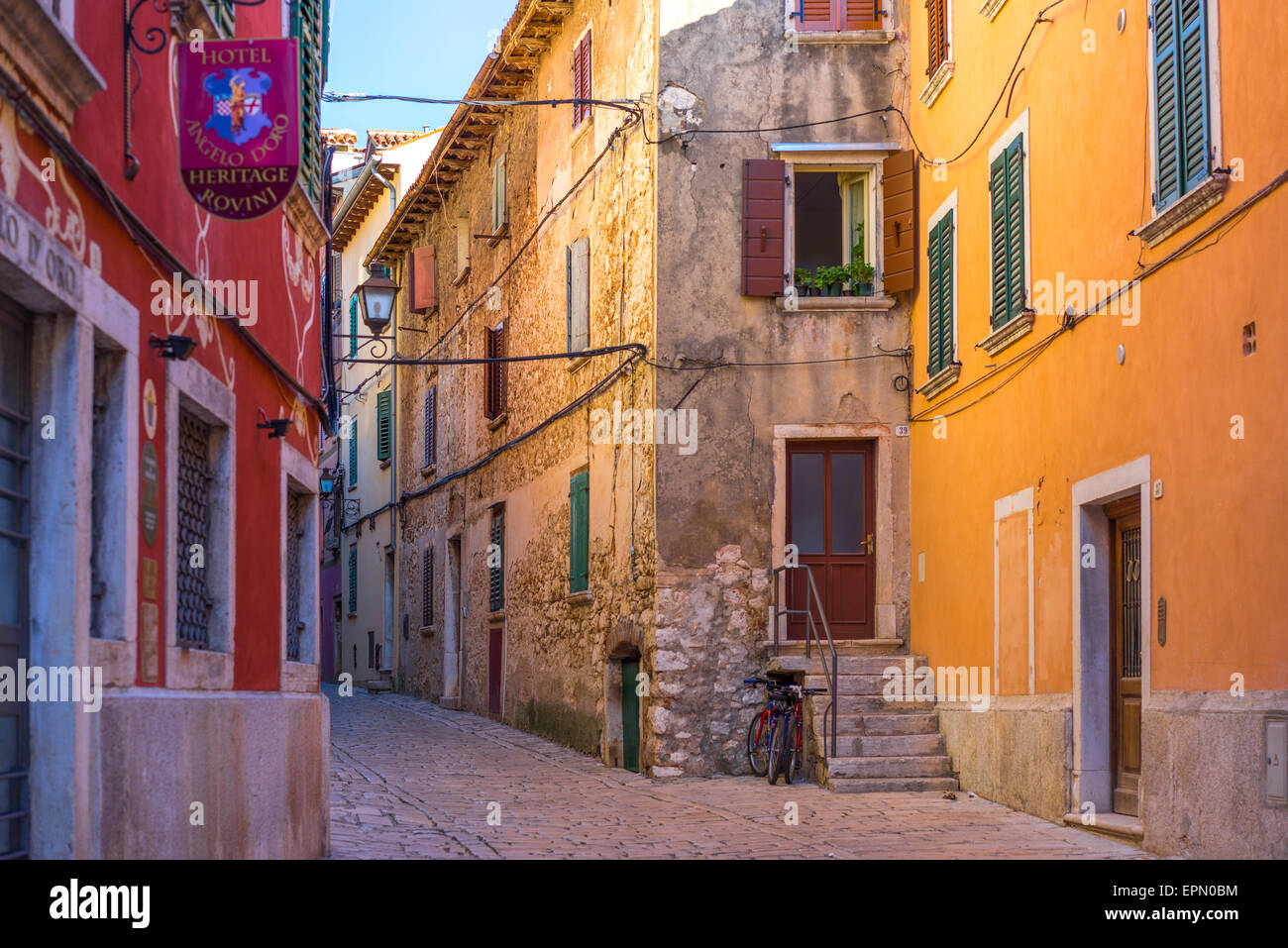 Early morning sun radiates in the narrow streets of brightly coloured venetian styled buildings, creating atmosphere and beauty Stock Photo