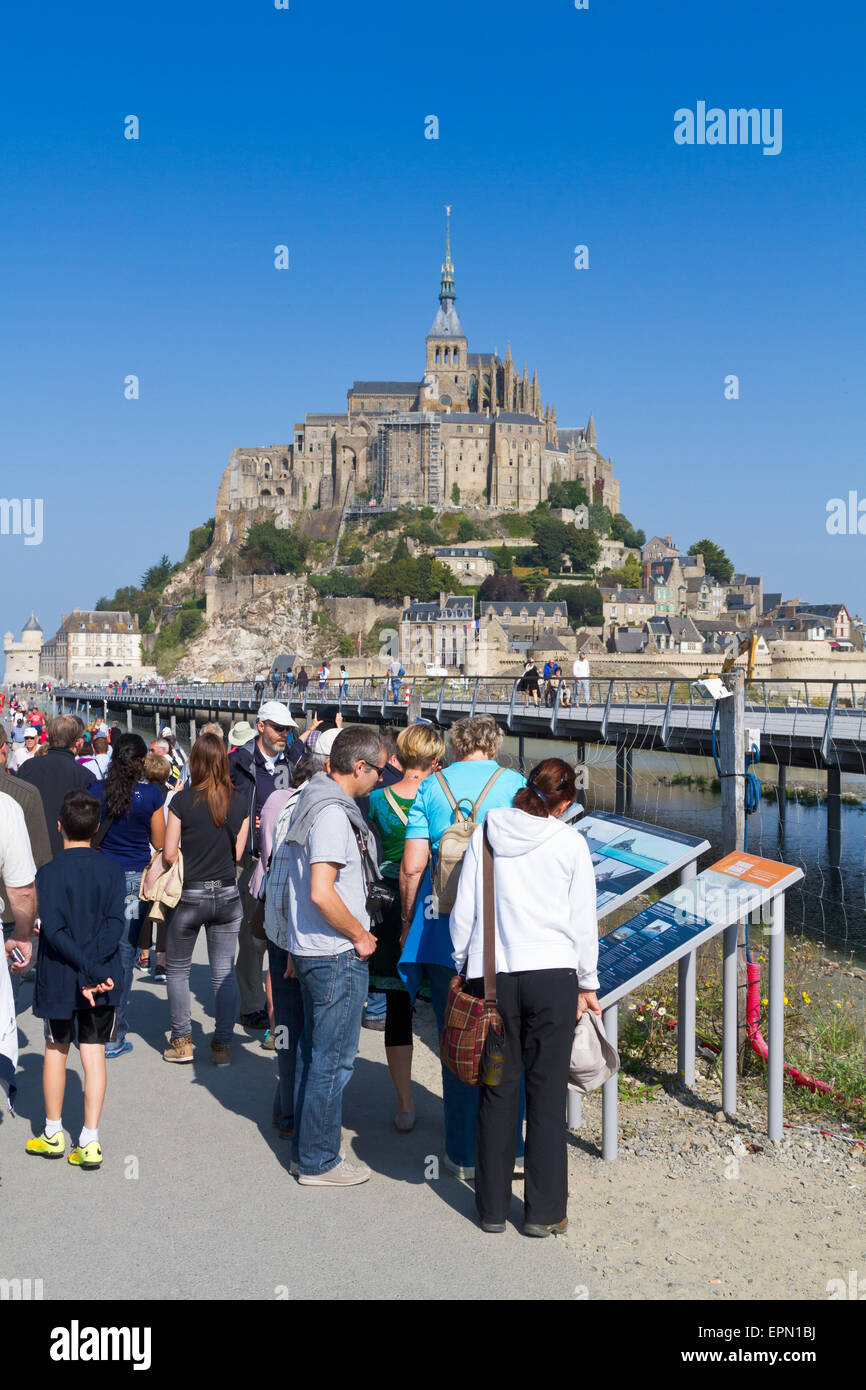 Tourists looking at signs for the new bridge at Mont St Michel Stock Photo