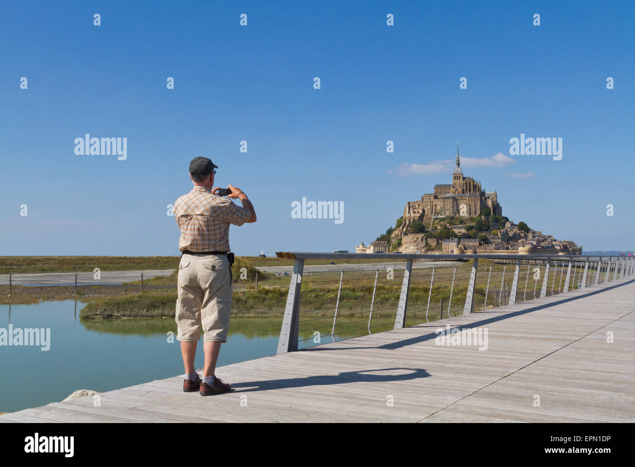 Man photographs Mont St Michel from the new bridge in September Stock Photo