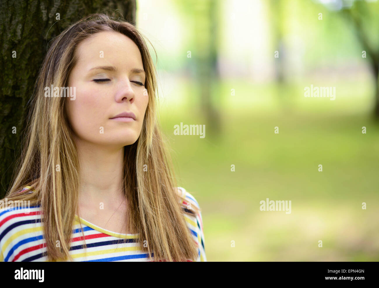 Young woman enjoying warm light of the sunset with eyes closed Stock ...