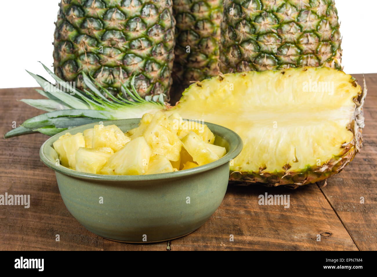 Pineapples with bowl of fresh cut pineapple fruit Stock Photo Alamy