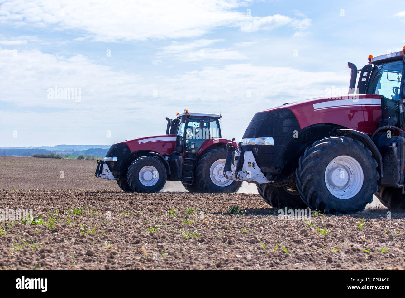 The tractor harrowing the large brown field in spring season Stock ...