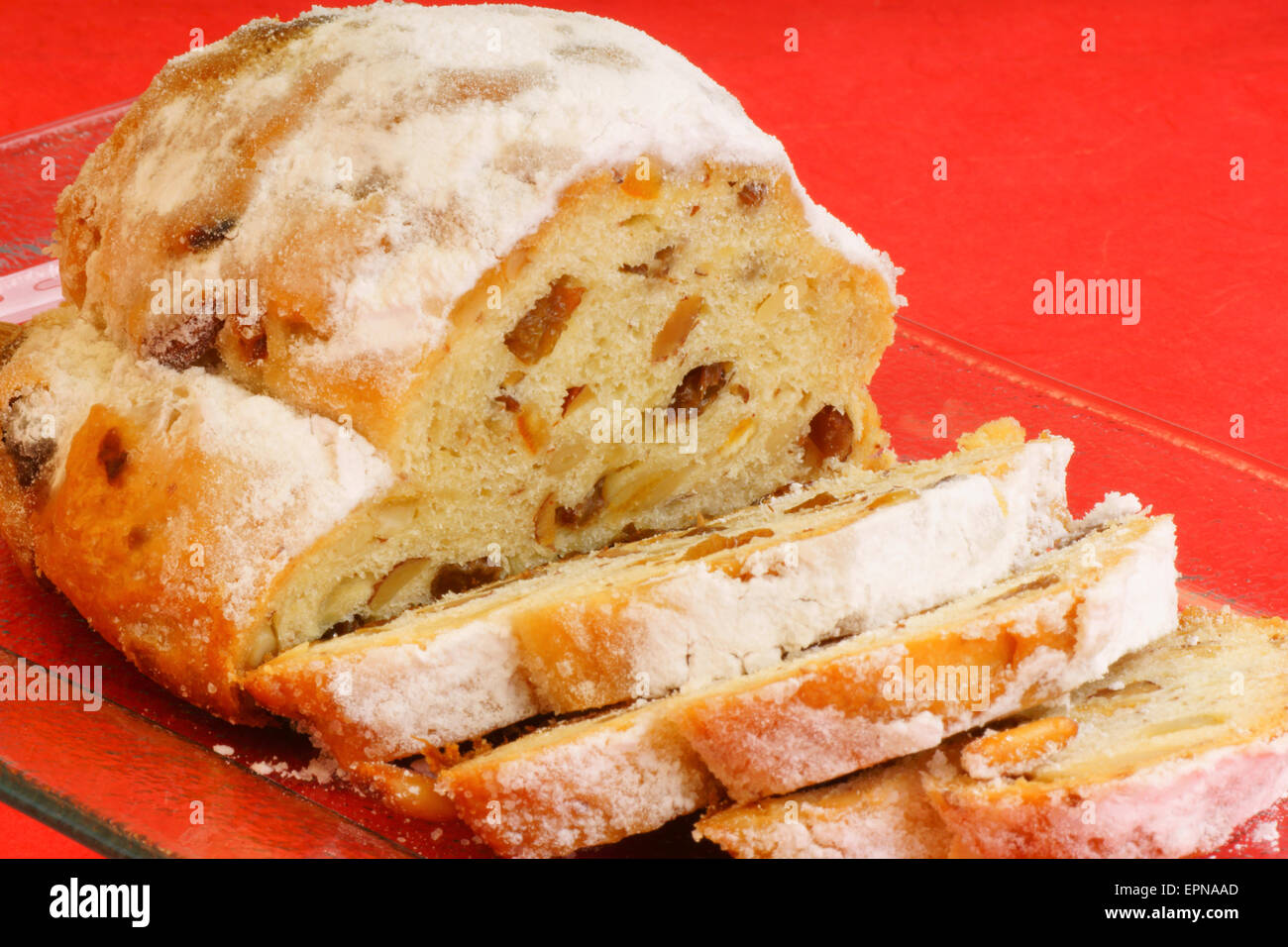 Sliced Christmas stollen the traditional german fruit cake made of bread-like pastry with candied fruit, almonds, cardamom and c Stock Photo