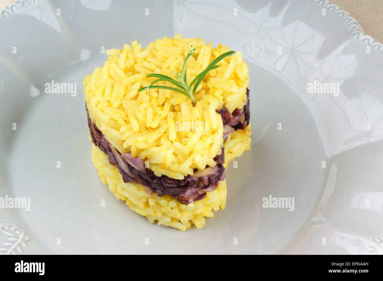 Heart shaped saffron rice with trevisano chicory, served on a grey plate. Idea for a Valentine's day dish. Stock Photo