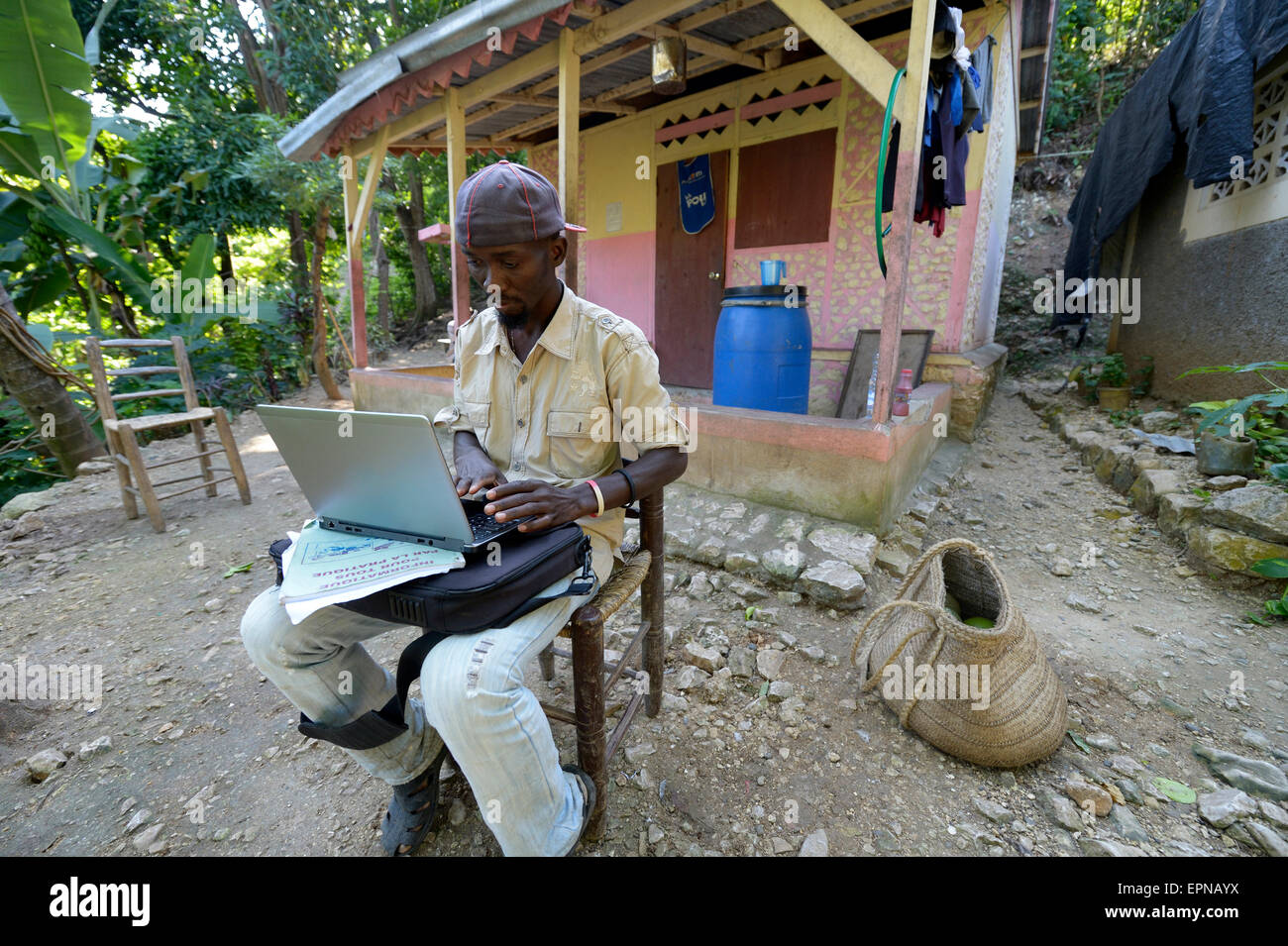 Man, 34 years old, sitting in front of his house with a laptop, Riviere