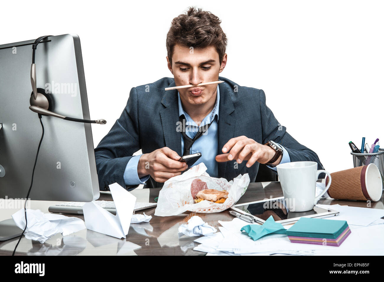 Slacker man using smartphone while getting hamburger / modern office man at working place, sloth and laziness concept Stock Photo