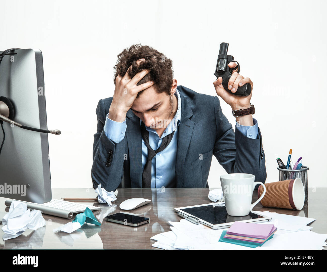 Manager with gun wants to commit suicide  / modern office man at working place, depression and crisis concept Stock Photo