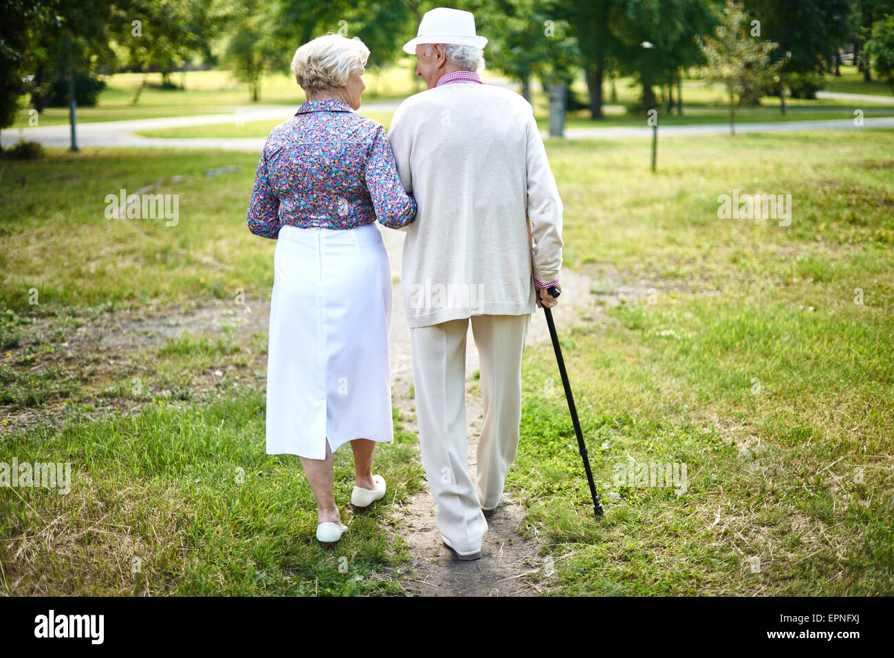 Rear view of well-dressed seniors taking a walk in summer Stock Photo ...