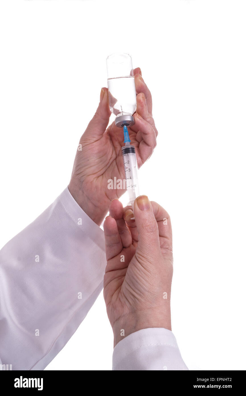 Filling of a syringe with medicine from vial. Medical person holding