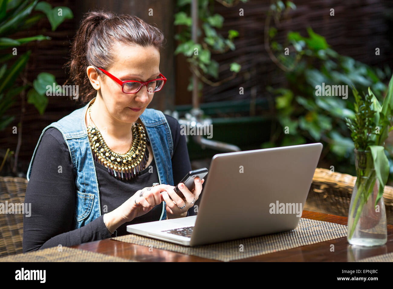 Young woman with laptop and smartphone in summer cafe Stock Photo - Alamy