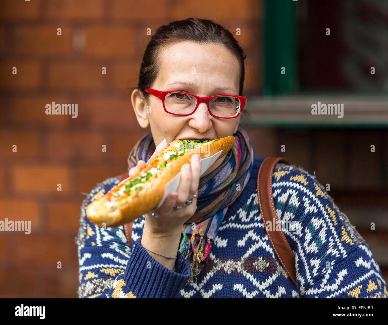 Young woman eating Polish fastfood casserole (Zapiekanka Stock Photo