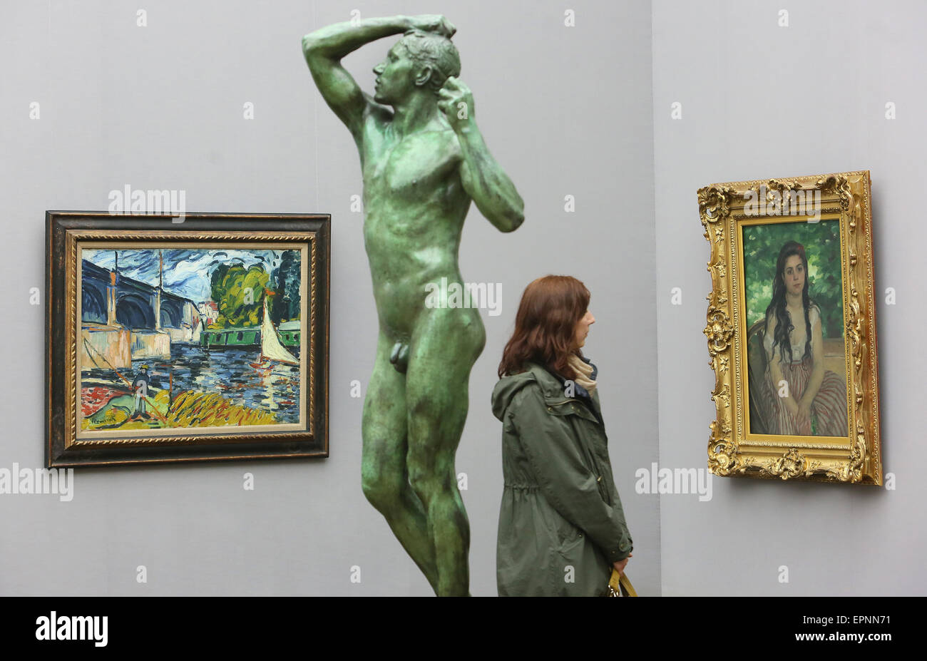 Berlin, Germany. 20th May, 2015. The pictures 'The Bridge at Chatou' (L, 1907)by Maurice de Vlaminck and 'In Summer' (1868) by Auguste Renoir can be seen next to the sculpture 'The Bronze Age' (1875/6) by Auguste Rodin at the Alte Nationalgalerie in Berlin, Germany, 20 May 2015. The pieces are part of the exhibition 'Impressionism - Expressionism. Turning Point in Art' - on display until 20 September 2015. Photo: STEPHANIE PILICK/dpa/Alamy Live News Stock Photo