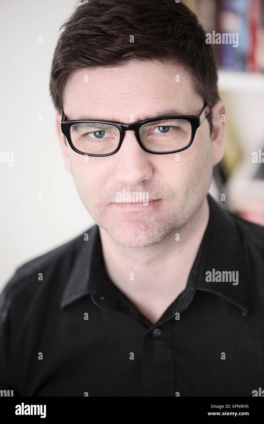 Portrait of man with glasses. He is looking at camera with a serious expression. Stock Photo