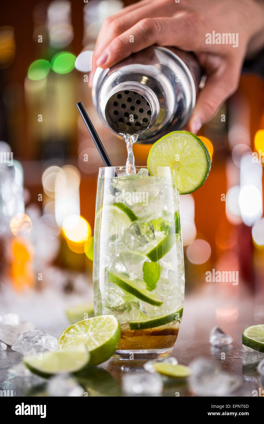 Mojito cocktail drink on bar counter with barman holding shaker on  background Stock Photo - Alamy
