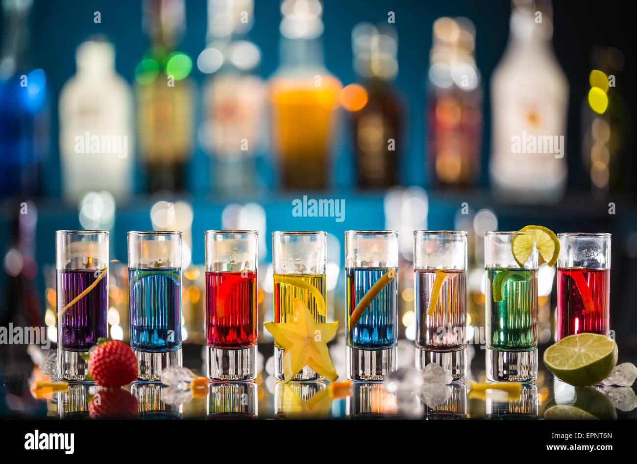 Variation of hard alcoholic shots served on bar counter. Blur bottles on background Stock Photo