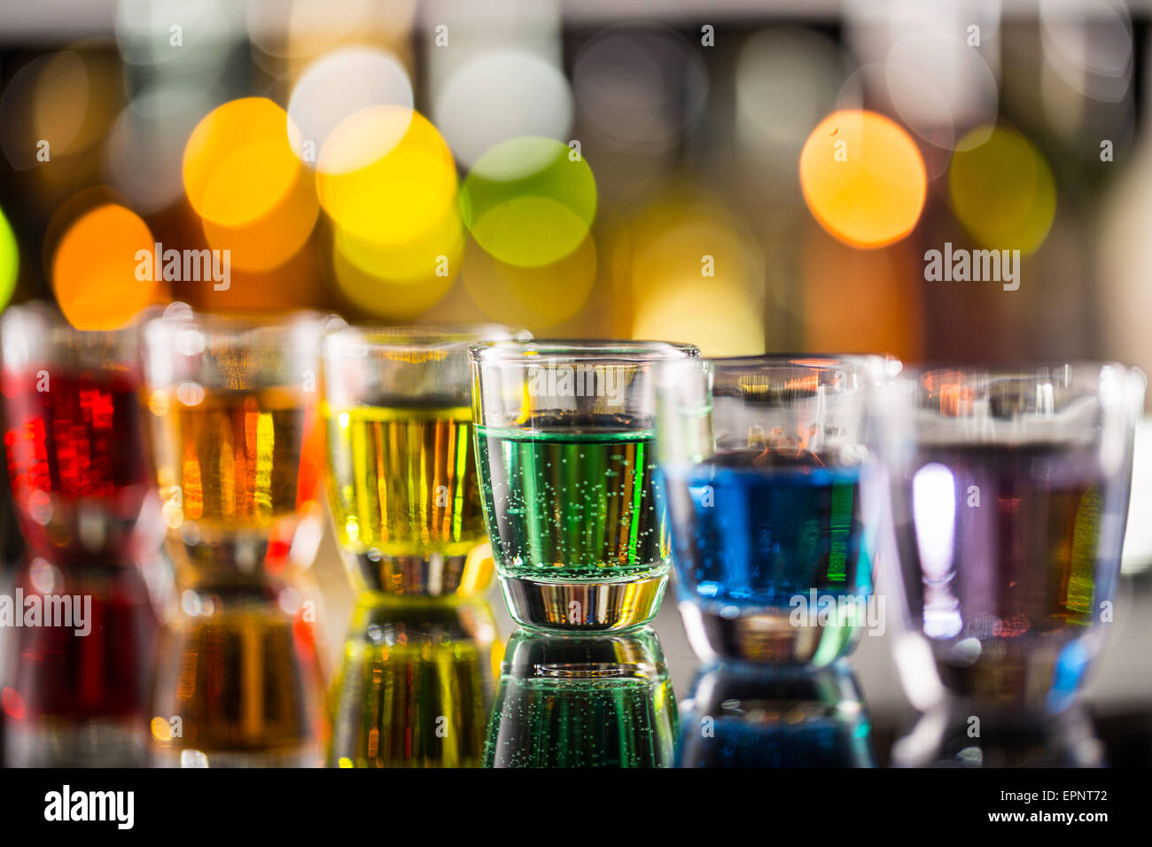 Variation of hard alcoholic shots served on bar counter. Blur bottles on background Stock Photo