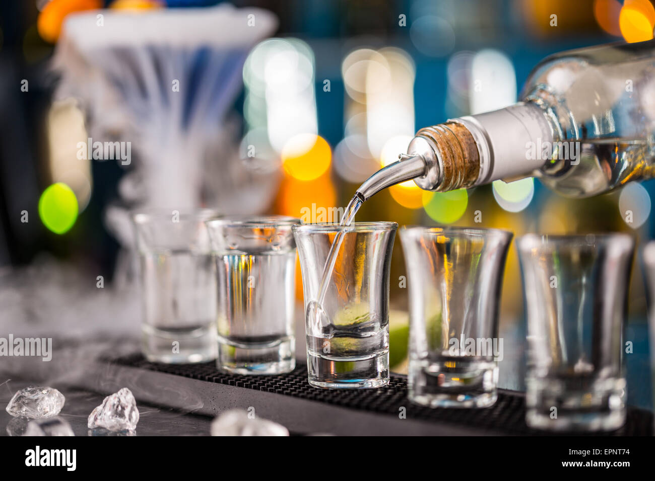 Barman pouring hard spirit into glasses in detail Stock Photo