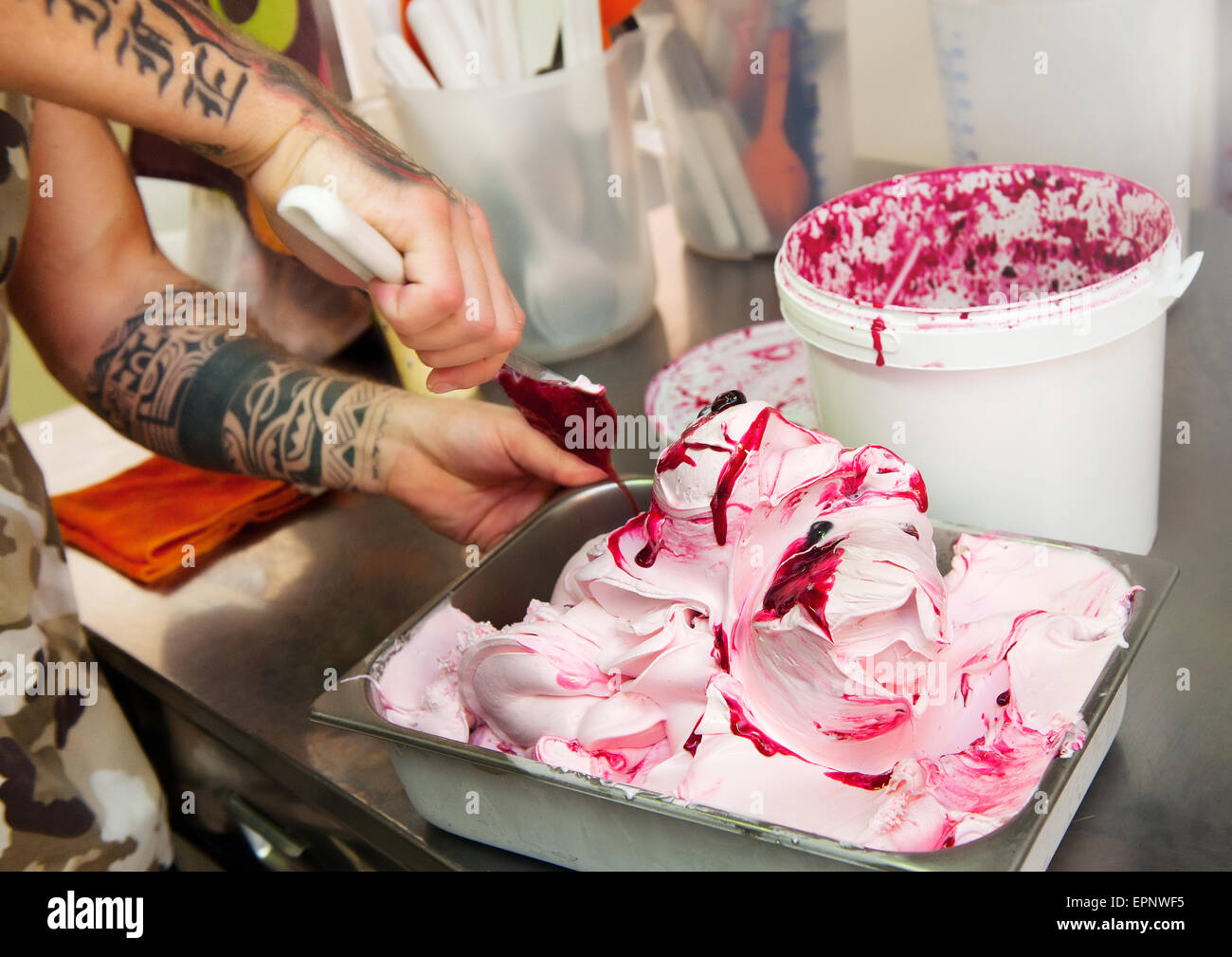 Man adding the variegating to fruit ice cream during the manufacturing