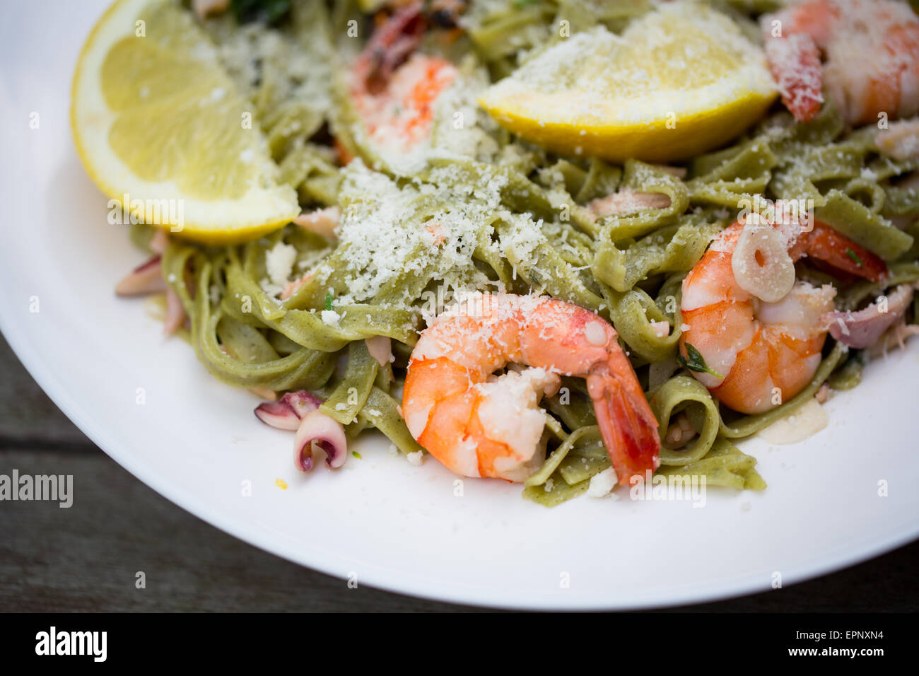 Dish of spinach tagliatelle pasta with king prawn, other seafood