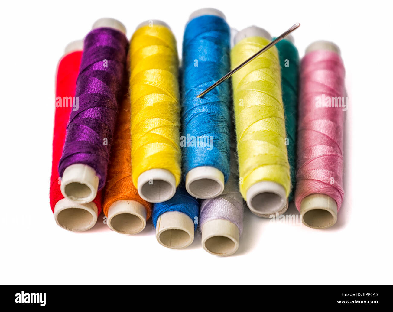 Closeup of colorful thread rolls and a needle Stock Photo - Alamy
