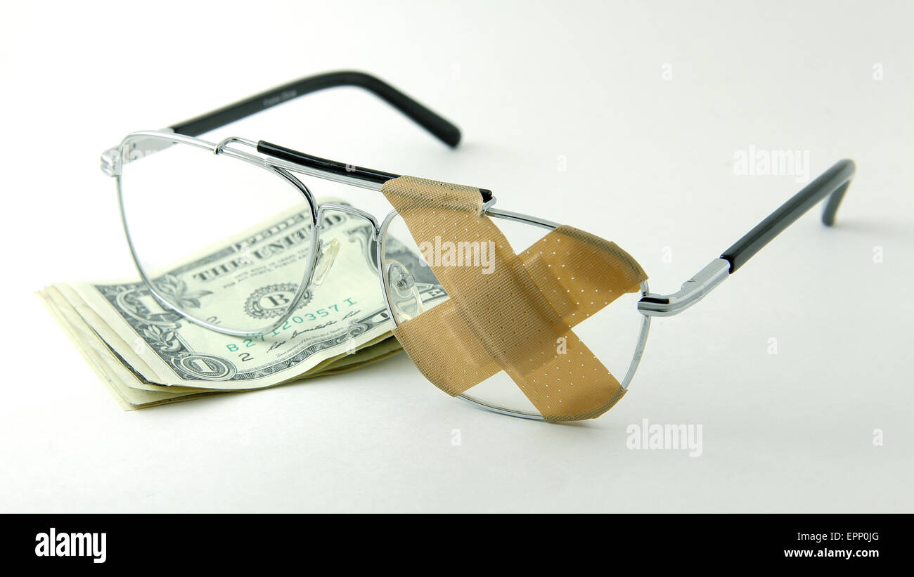 Eye glasses with bandaid X and dollar bills healthcare is expensive