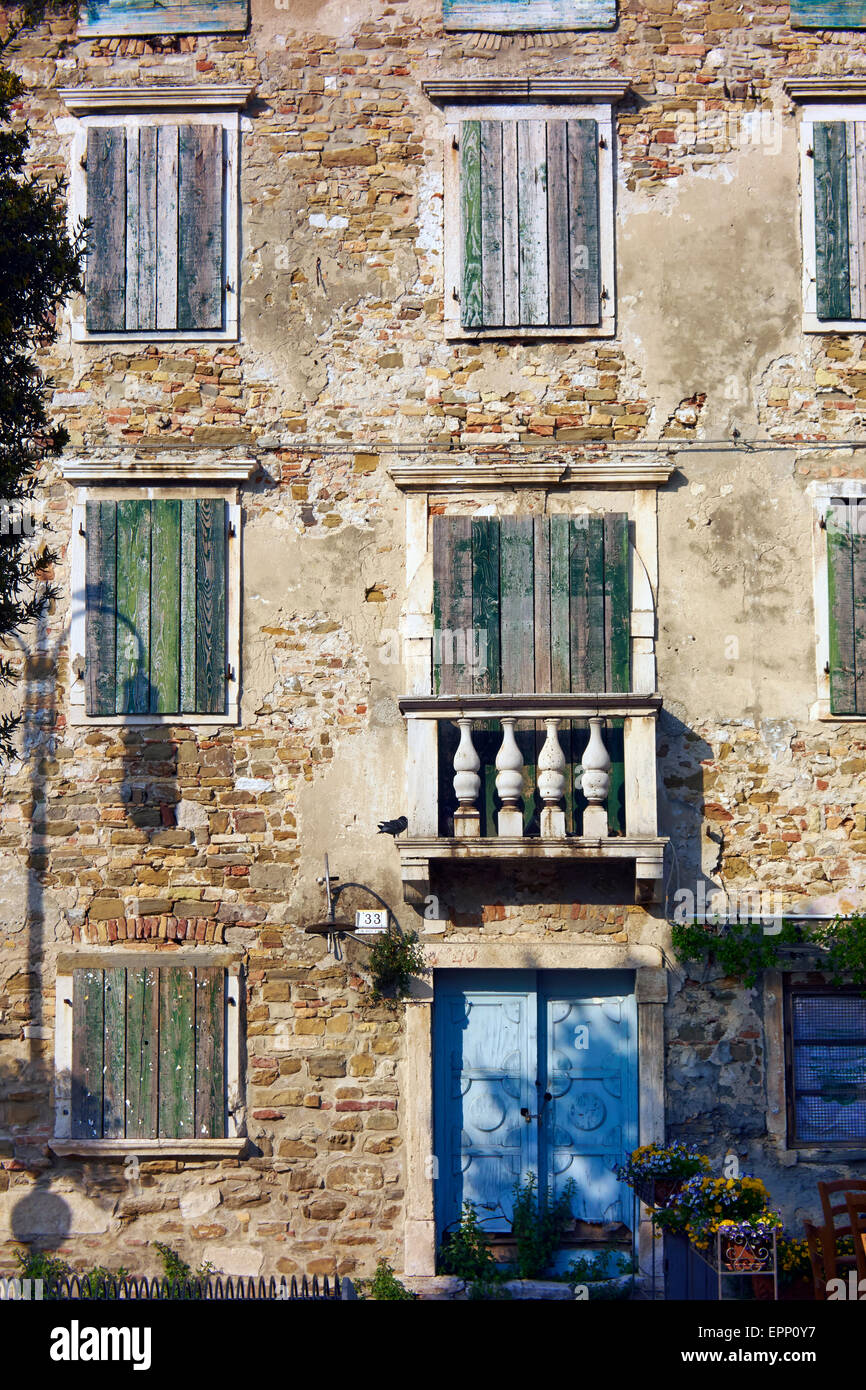 Old house facade with shuttered windows in Grado, Friuli - Venezia Giulia, Italy, Adriatic Sea. Stock Photo