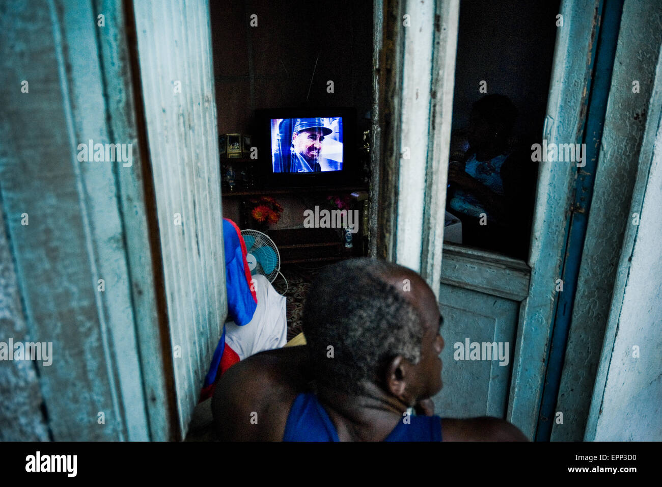 A Cuban man watches TV broadcasting of the Cuban Revolution anniversary