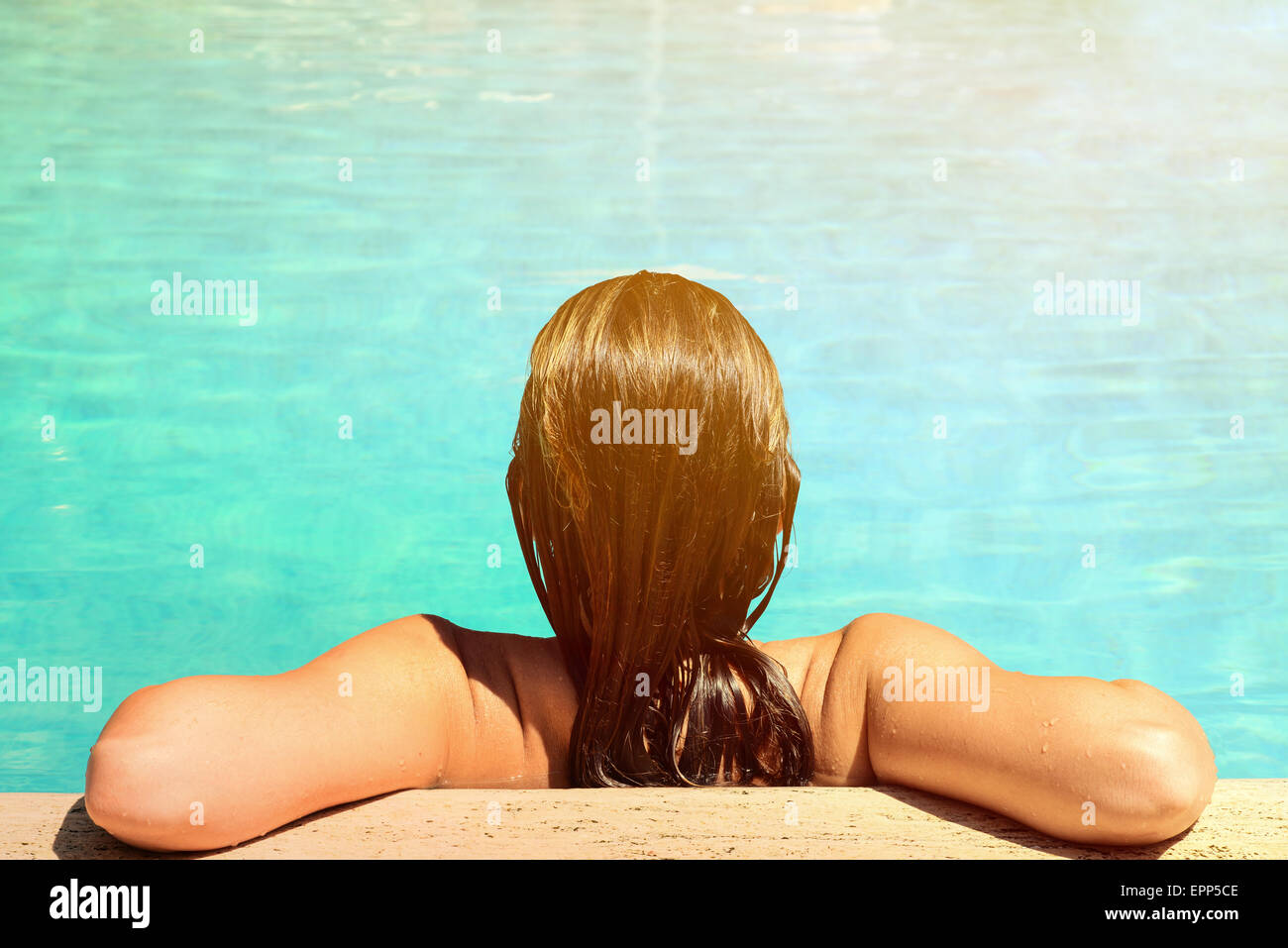 Back view of relaxed woman in swimming pool with blue water Stock Photo ...