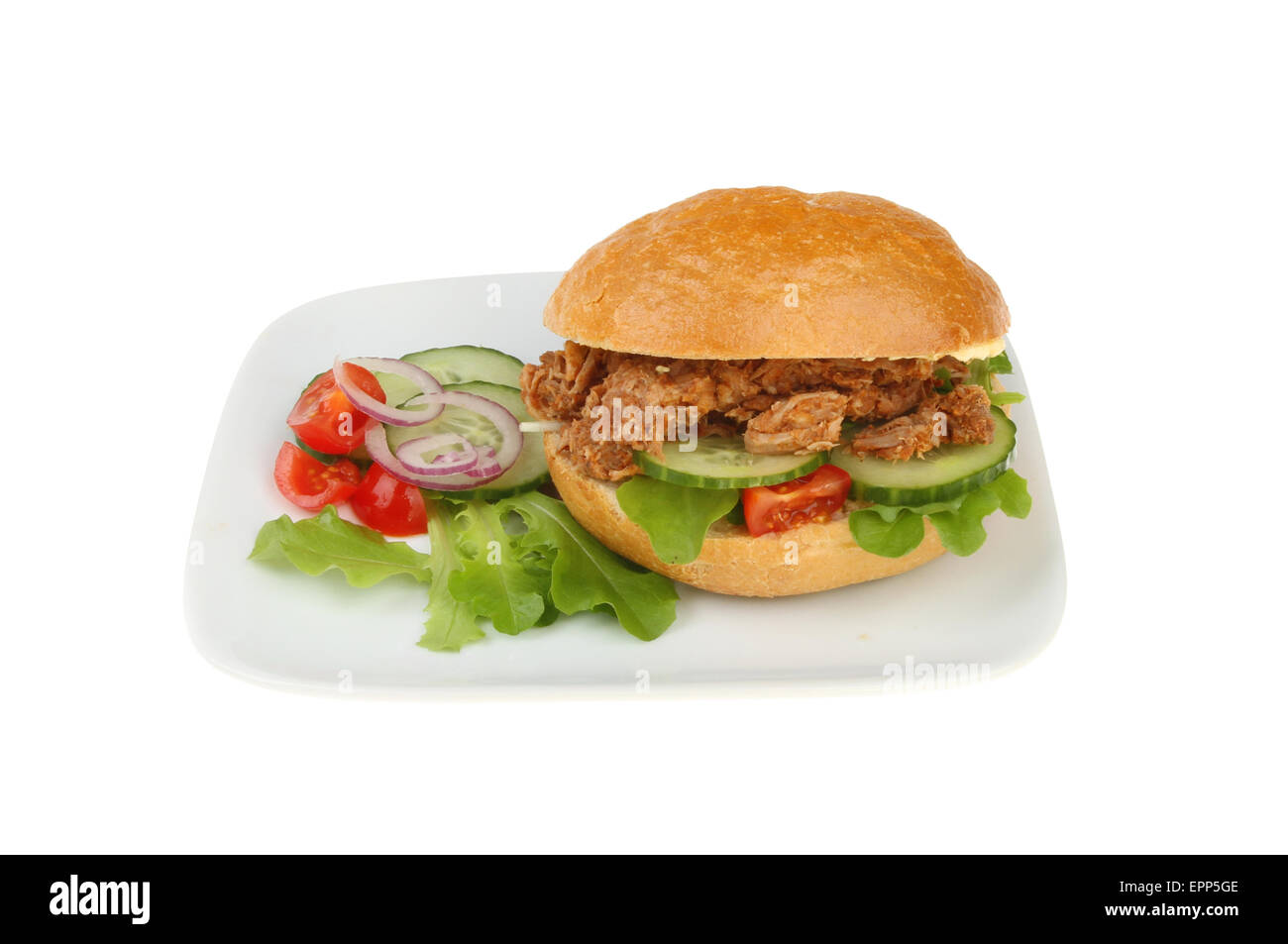 Bread roll filled with pulled pork, salad with a salad garnish on a plate isolated against white Stock Photo