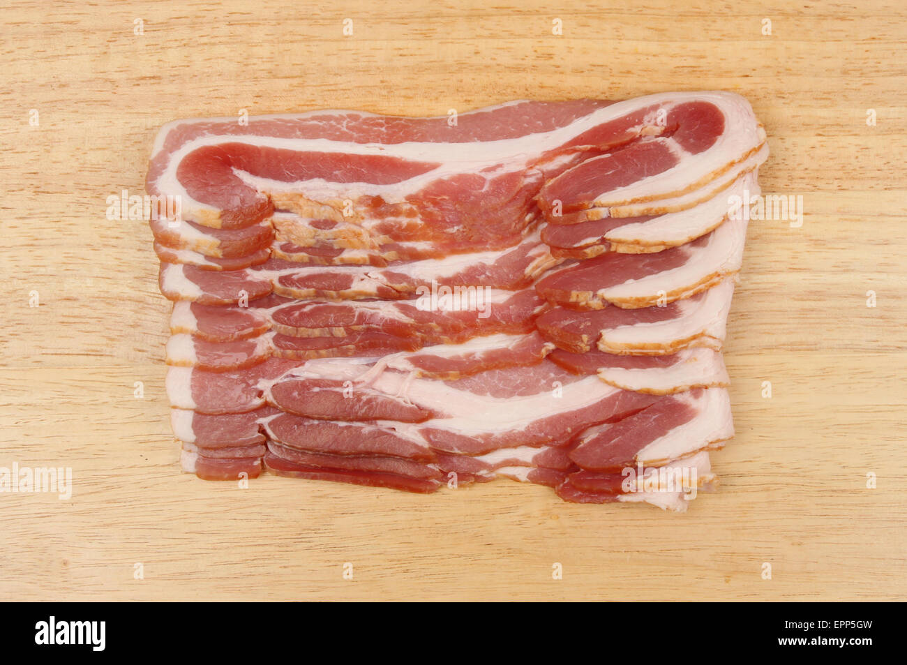 Rashers of streaky bacon on a wooden board Stock Photo