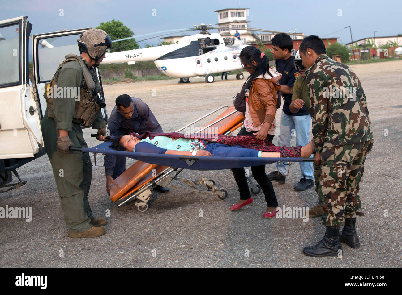 U.S. service members from Joint Task Force 505 and Nepalese soldiers move a victim onto an ambulance at Tribhuvan International Airport May 19, 2015 in Kathmandu, Nepal. A 7.3 magnitude aftershock earthquake struck the kingdom on May 12th following the 7.8 magnitude earthquake on April 25th. Stock Photo