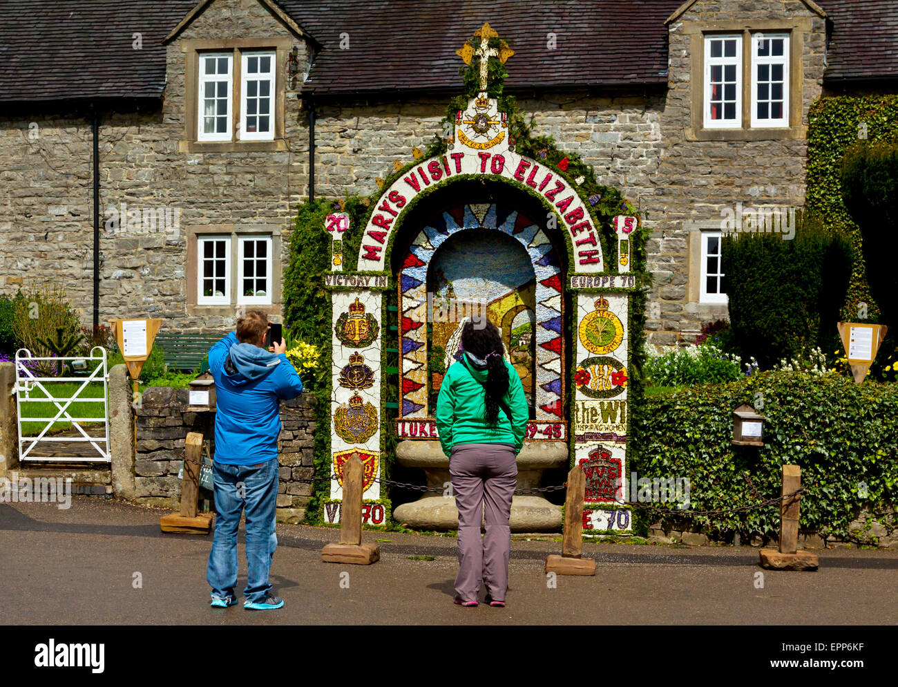 Tourists admiring a traditional Well Dressing in Tissington village an annual event in the Derbyshire Peak District England UK Stock Photo