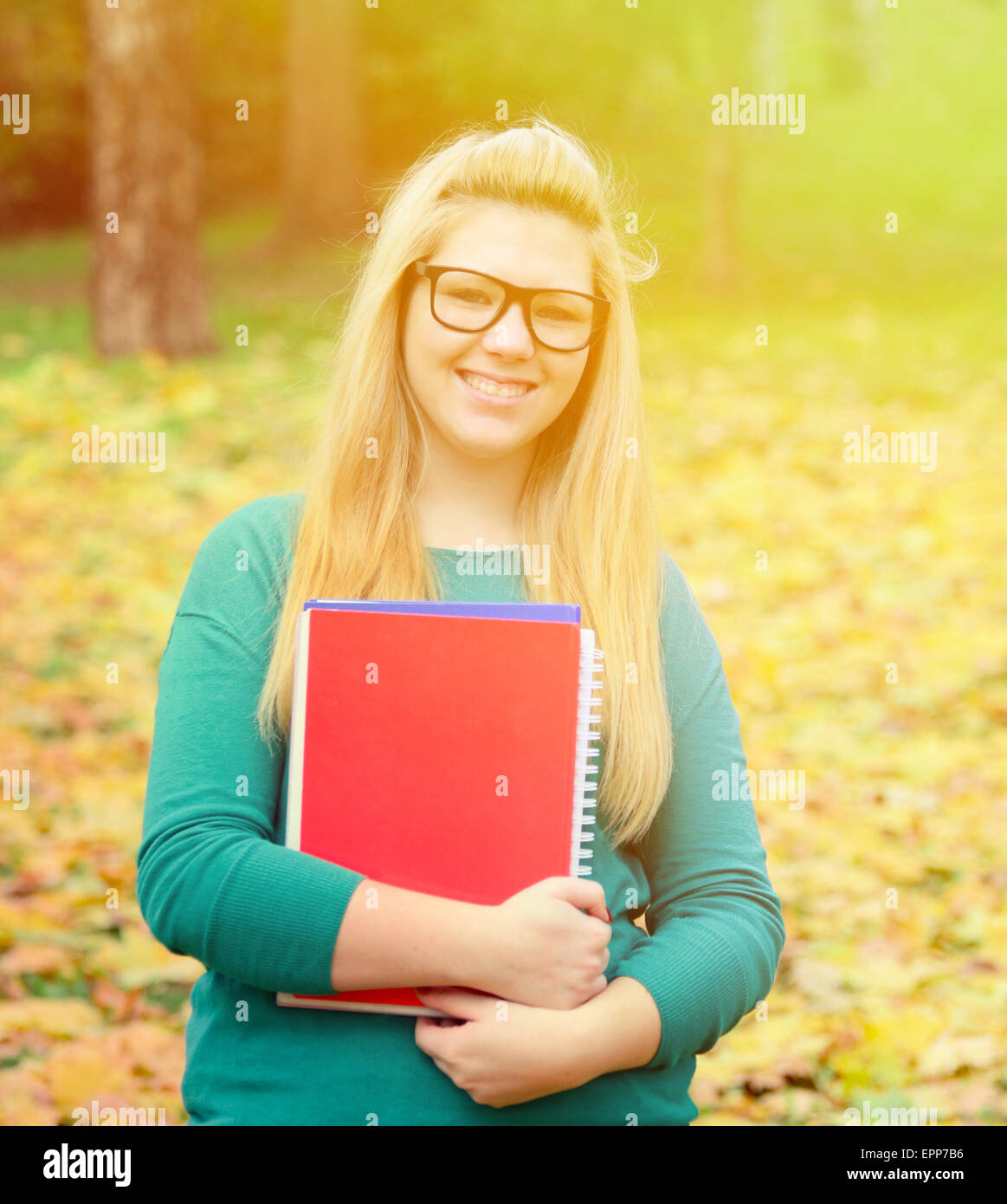 Beautful smiling blonde student girl holding books Stock Photo - Alamy
