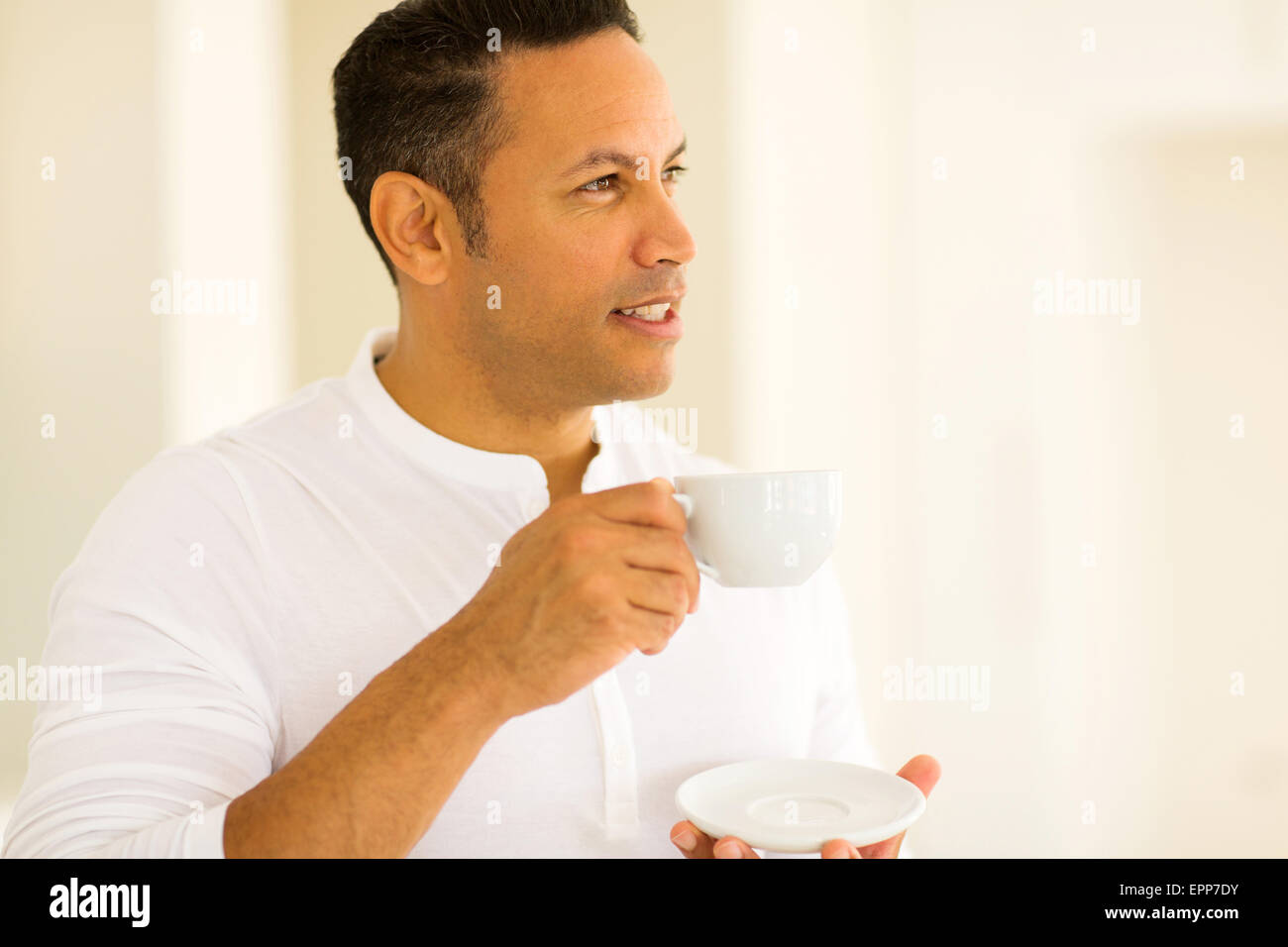 thoughtful man having cup of coffee indoors Stock Photo