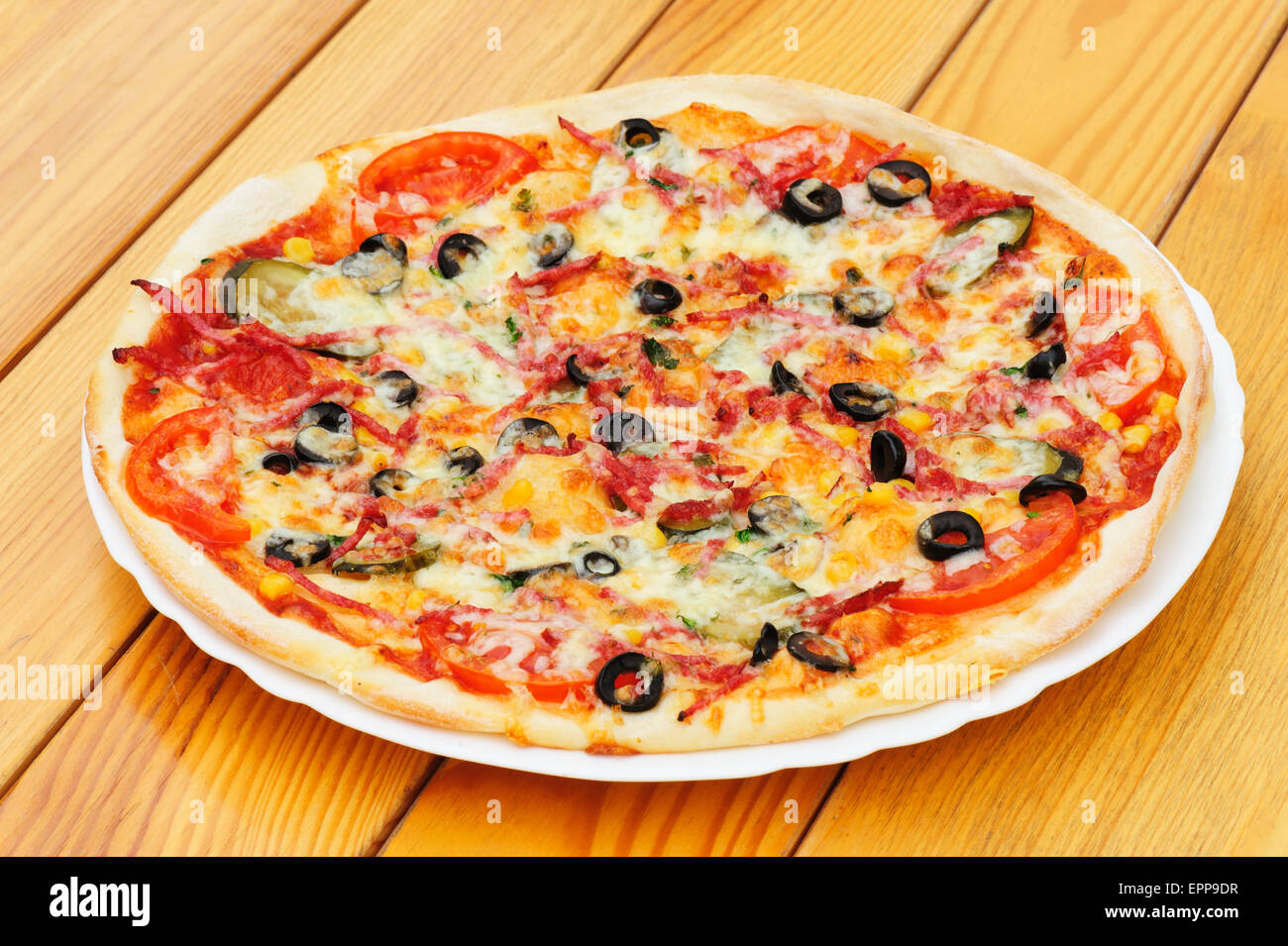 Pizza with pepperoni, black olives and corn Stock Photo