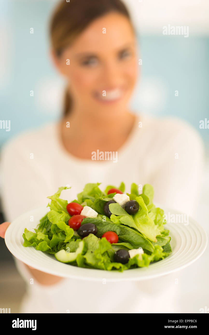 happy young woman presenting healthy green salad Stock Photo