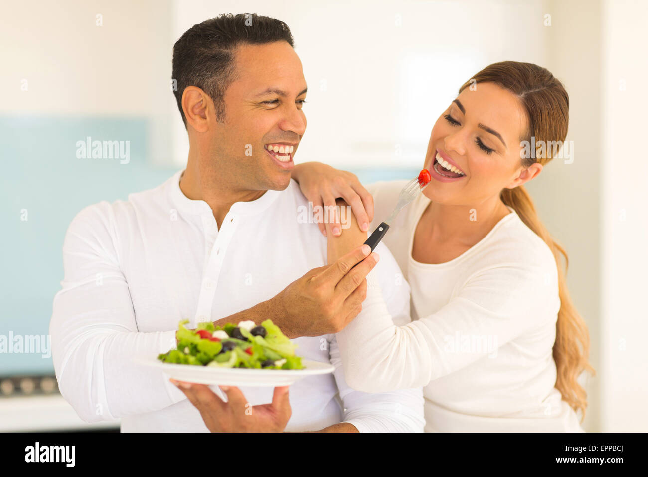loving husband feeding wife salad at home Stock Photo