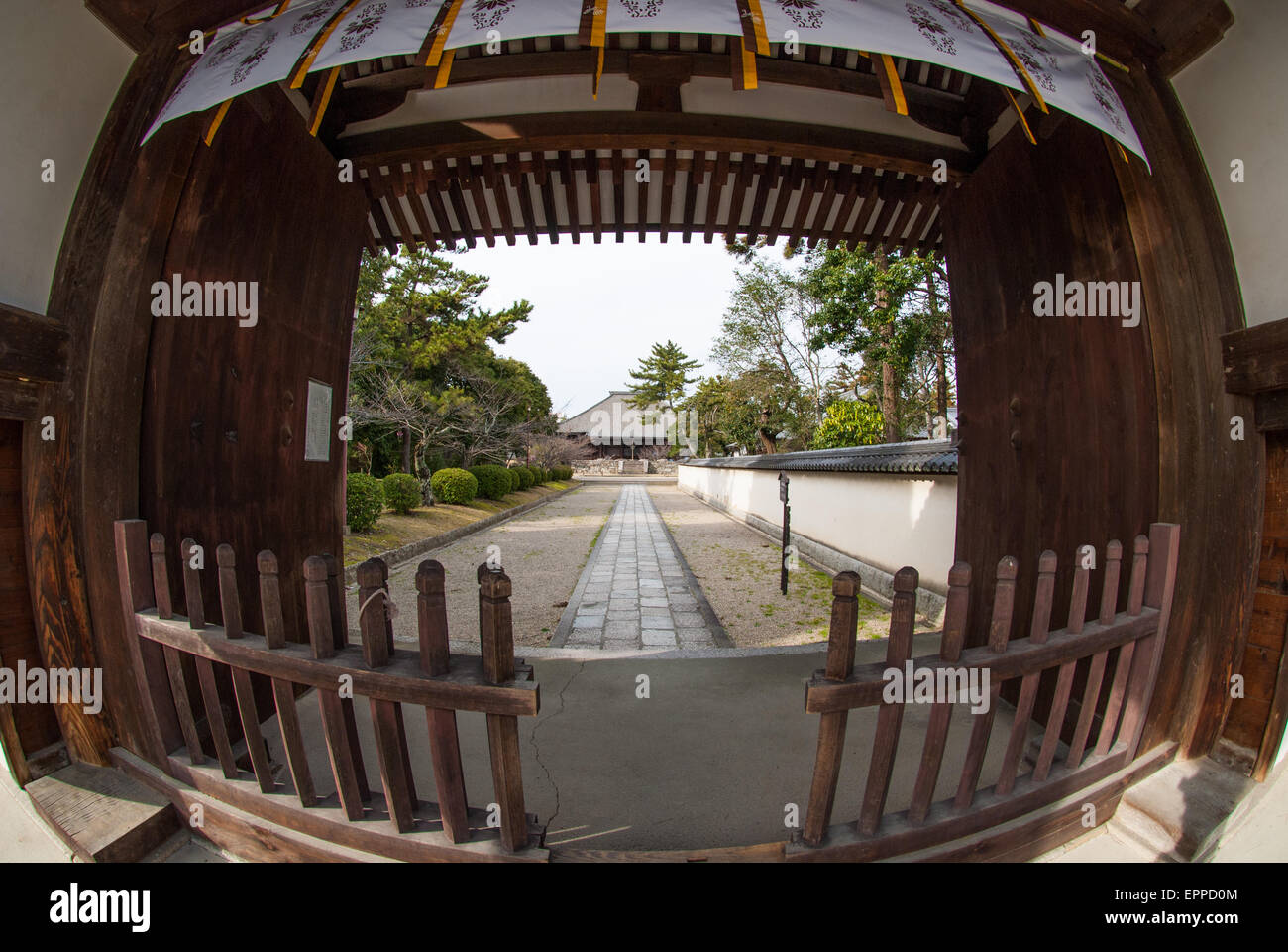 the wide view of the wooden entrance and fences of a temple in Nara. Stock Photo