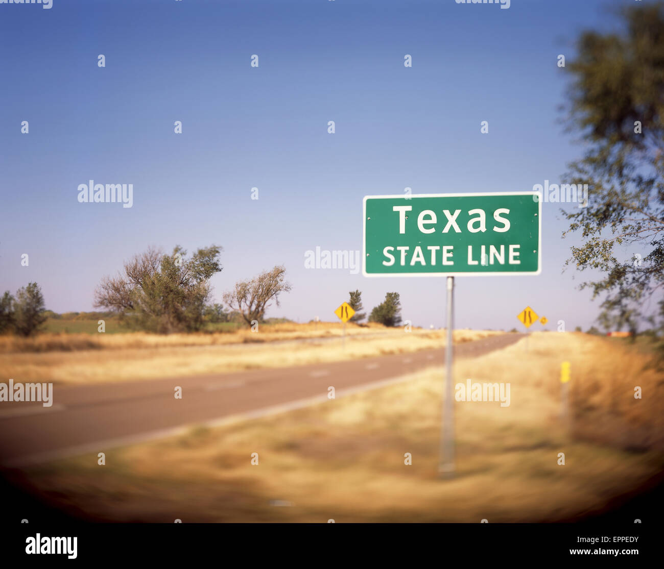 A Texas State Line sign on a back road in Oklahoma lets the driver know that they are about to enter the Great State. Stock Photo