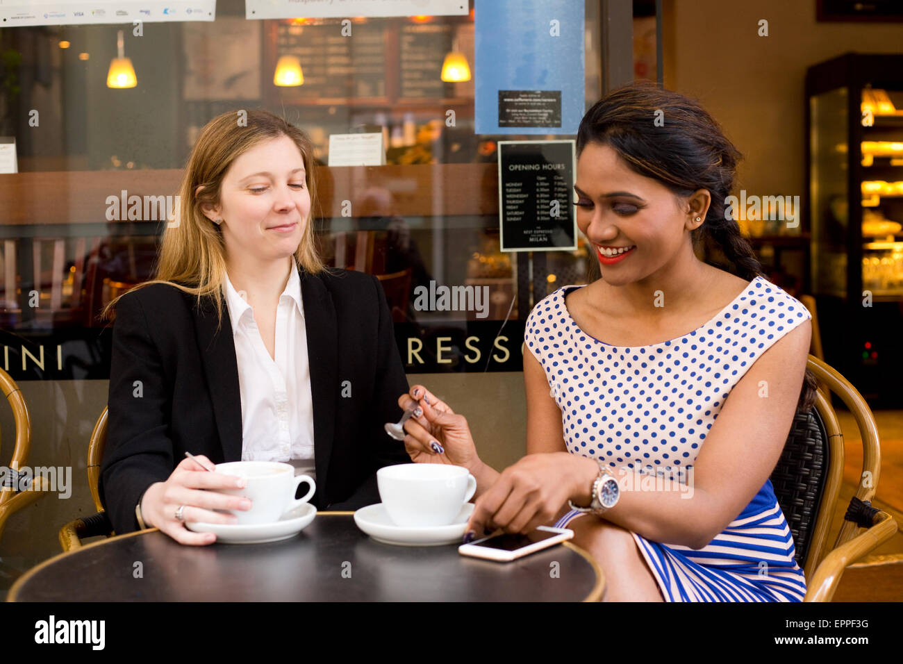 work colleagues sitting outside a coffee shop Stock Photo
