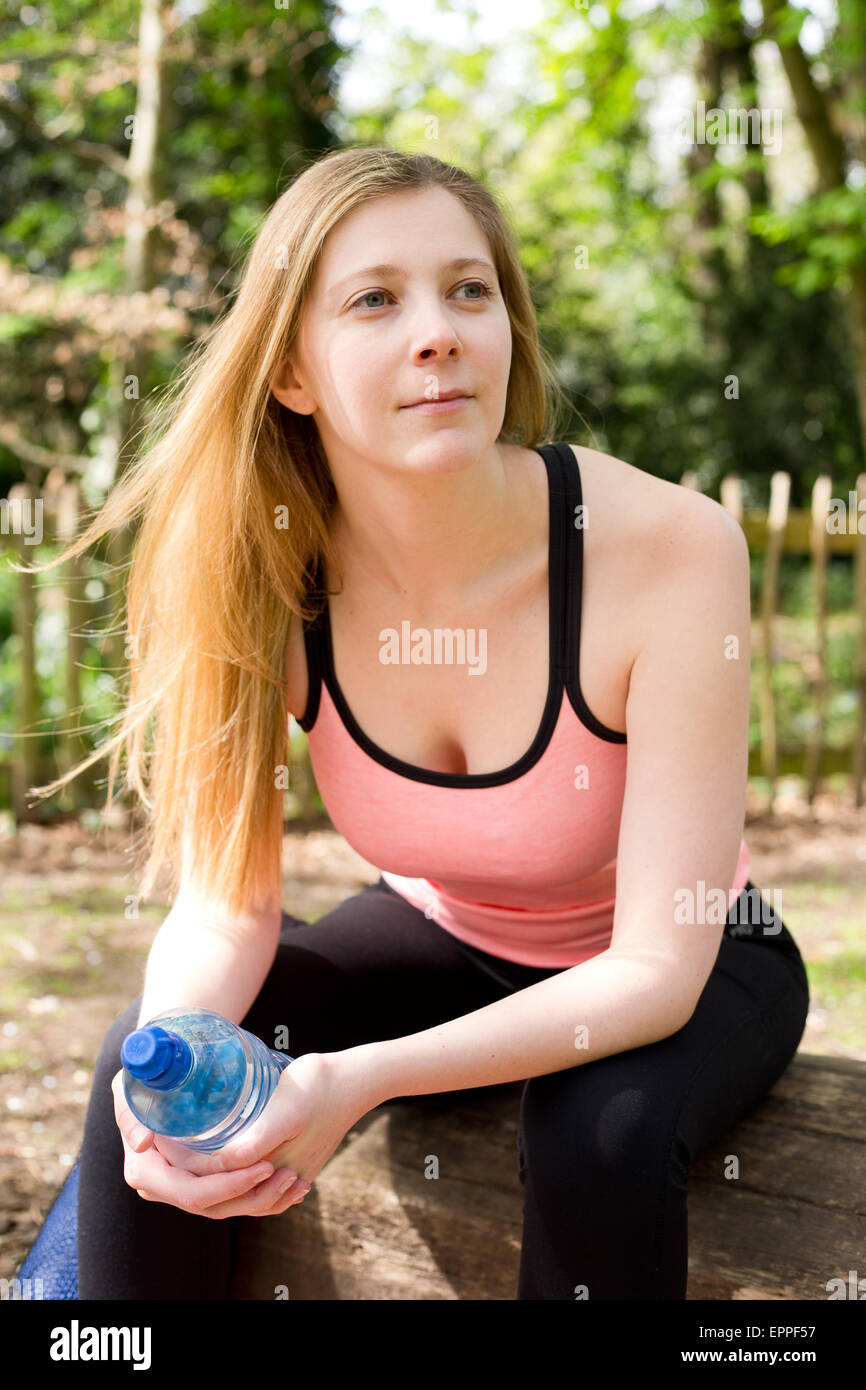 young woman sitting on a bench resting after exercise Stock Photo - Alamy