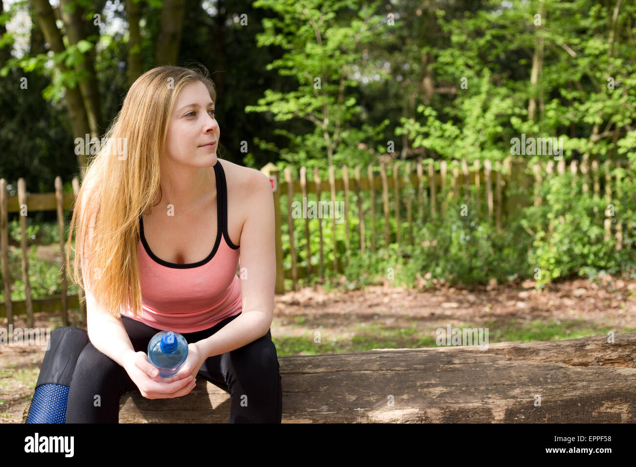 young woman sitting on a bench resting after exercise Stock Photo - Alamy