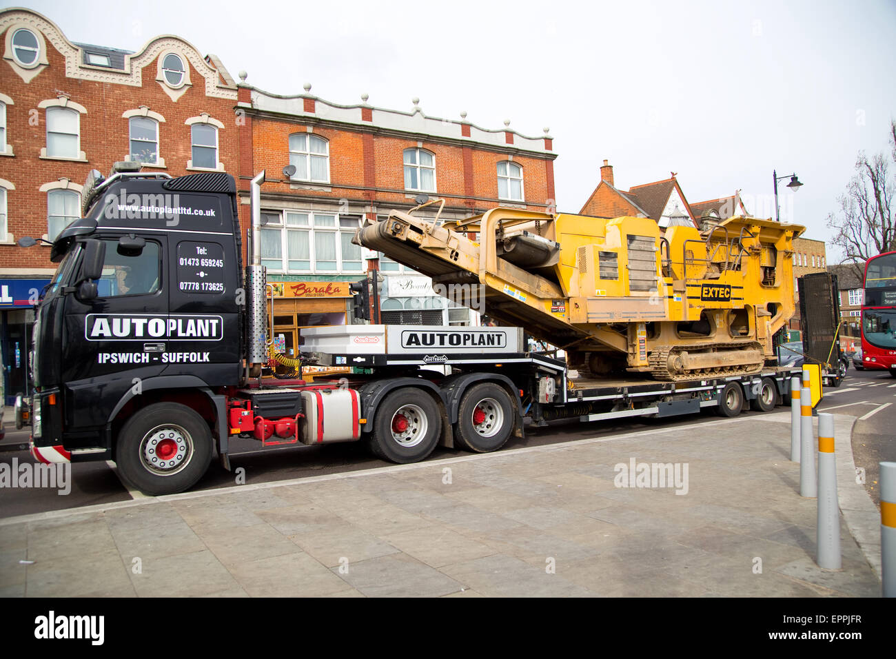 LONDON - MARCH 30TH: A transporter  carries a rock crushing machine on March the 30th, 2015, in London, England, UK. Rock crushe Stock Photo