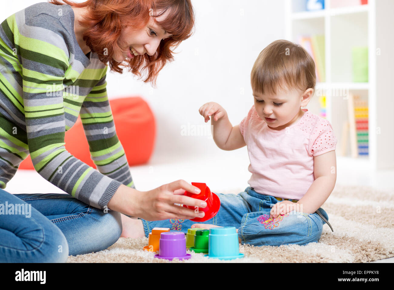 cute mother and her daughter play together indoor Stock Photo