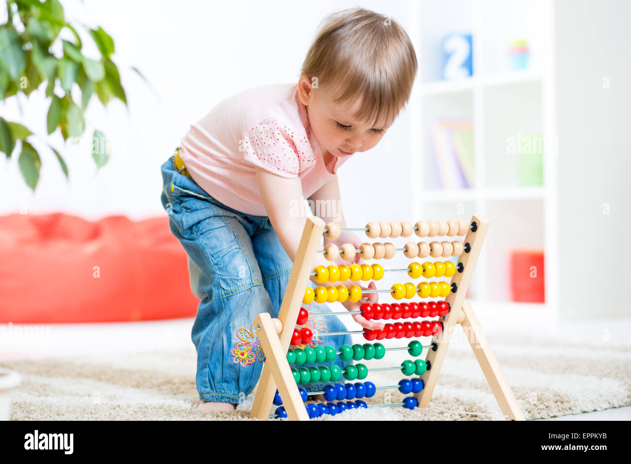 child girl playing with counter toy at nursery Stock Photo Alamy