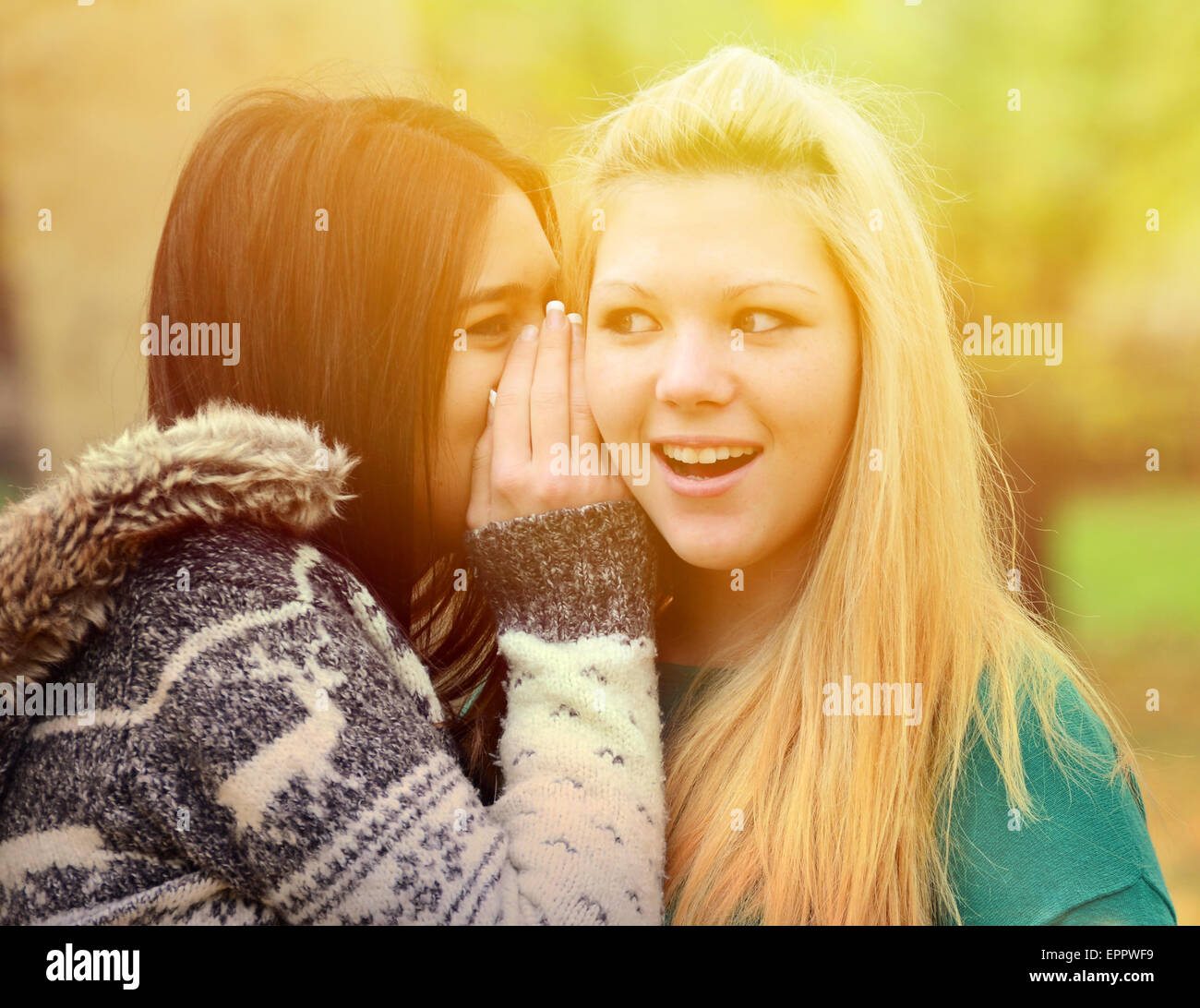 Two teen girls whispering rumours Stock Photo - Alamy