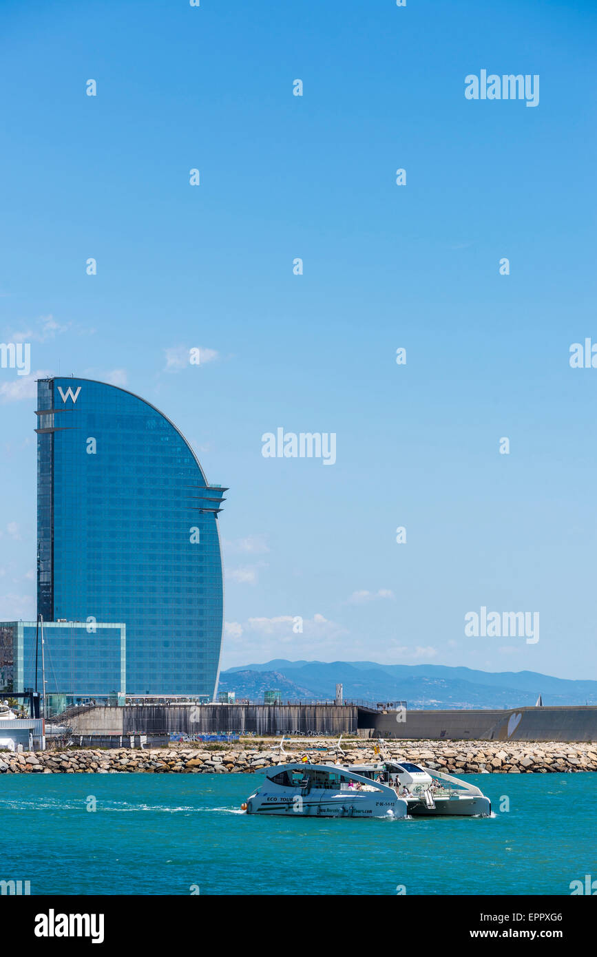 Catamaran sailing with the W hotel in the background in Barcelona, Catalonia, Spain Stock Photo